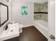 Bathroom featuring dark wood floors, sleek vanity with modern fixtures, and a tiled shower over tub at 4357 Treeline Way, Douglasville, GA 30135