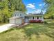 Charming two-story home with a two-car garage, blooming azaleas, and manicured lawn at 4357 Treeline Way, Douglasville, GA 30135