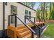 Deck with staircase featuring black metal railing, wood surface, and lush green yard at 1481 Almont Sw Dr, Atlanta, GA 30310