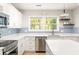 Modern kitchen with stainless appliances, gas range, and white cabinets with backsplash at 1481 Almont Sw Dr, Atlanta, GA 30310