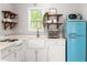 The kitchen features a retro-style fridge, white cabinets, wooden shelves, and a window at 1481 Almont Sw Dr, Atlanta, GA 30310