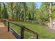 Gated backyard featuring green grass, tall trees, black rock and deck at 1481 Almont Sw Dr, Atlanta, GA 30310