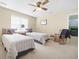 Well-lit bedroom with two twin beds, complemented by a window and ceiling fan at 1488 Rivermist Sw Dr, Lilburn, GA 30047