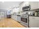 Modern kitchen with stainless steel appliances and white cabinets at 1488 Rivermist Sw Dr, Lilburn, GA 30047
