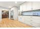 Bright kitchen featuring white cabinets, stainless steel appliances, and hardwood flooring at 1488 Rivermist Sw Dr, Lilburn, GA 30047
