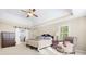 Elegant main bedroom with a tray ceiling, fan, and barn door to an adjoining bathroom or closet at 1488 Rivermist Sw Dr, Lilburn, GA 30047
