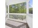 Inviting porch with white railings and pillars, offering a serene view of the trees at 1488 Rivermist Sw Dr, Lilburn, GA 30047