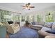 Bright sunroom with large windows, comfortable seating, and a ceiling fan at 1488 Rivermist Sw Dr, Lilburn, GA 30047