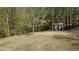 Backyard with a storage building and mature trees; bird feeder visible in foreground at 158 Grove Meadow Dr, Acworth, GA 30101