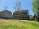 Extensive grassy backyard with view of the home's exterior at 158 Grove Meadow Dr, Acworth, GA 30101