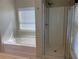 A bathtub and glass enclosed shower in a well-lit bathroom at 158 Grove Meadow Dr, Acworth, GA 30101