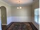 Charming dining room featuring decorative wall trim, stylish chandelier, and a large window at 158 Grove Meadow Dr, Acworth, GA 30101