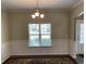 Inviting dining room with decorative wall trim, chandelier, and a bright window view at 158 Grove Meadow Dr, Acworth, GA 30101