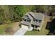Aerial view of a two-story home with a lush tree lined backyard and driveway at 158 Grove Meadow Dr, Acworth, GA 30101