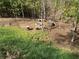 Scenic backyard firepit area with custom seating surrounded by a lush wooded landscape at 158 Grove Meadow Dr, Acworth, GA 30101
