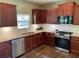 Close-up of kitchen featuring granite countertops, stainless steel appliances, and cherry cabinets at 158 Grove Meadow Dr, Acworth, GA 30101