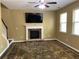 Cozy living room featuring a fireplace, ceiling fan, and large windows for natural light at 158 Grove Meadow Dr, Acworth, GA 30101