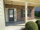 Welcoming porch featuring stacked stone accents, overhead lighting, and lush landscaping at 158 Grove Meadow Dr, Acworth, GA 30101