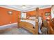 Traditional bedroom showcasing a four-poster bed, neutral carpet, and bright orange walls at 31 Churchill Downs Ne, Cartersville, GA 30121