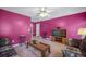 Cozy living room with bright pink walls, plush carpet, a ceiling fan, and comfortable furniture at 31 Churchill Downs Ne, Cartersville, GA 30121