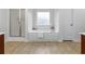Elegant bathroom featuring a soaking tub, tiled floors, and ample natural light at 5484 Stone Cove Sw Dr, Atlanta, GA 30331