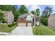 A two-story brick house with green lawn, mature trees, and three car garage at 5484 Stone Cove Sw Dr, Atlanta, GA 30331