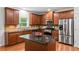 A kitchen is equipped with wooden cabinets, stainless steel appliances, a kitchen island, and hardwood floors at 5484 Stone Cove Sw Dr, Atlanta, GA 30331