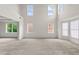 Open-concept living room with ample natural light, plush carpeting, and neutral decor at 5484 Stone Cove Sw Dr, Atlanta, GA 30331