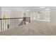 Open loft area with a railing, carpeted floors, and plenty of natural light, versatile for any use at 5484 Stone Cove Sw Dr, Atlanta, GA 30331