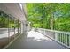 Spacious grey back deck with sliding glass doors and white railing overlooking lush green trees at 7320 Oak Arms Dr, Villa Rica, GA 30180