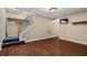 Finished basement featuring stylish wood flooring, staircase, and TV area at 7320 Oak Arms Dr, Villa Rica, GA 30180