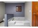 Elegant bathroom with a soaking tub and a stylish, dark grey accent wall at 7320 Oak Arms Dr, Villa Rica, GA 30180