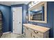 Stylish bathroom featuring a vanity with a stone countertop and a decorative mirror at 7320 Oak Arms Dr, Villa Rica, GA 30180