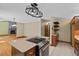 Open kitchen with granite counters, cooktop island and view to breakfast area with wood-burning fireplace at 7320 Oak Arms Dr, Villa Rica, GA 30180