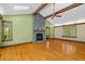 Bright living room with hardwood floors, stone fireplace, vaulted ceiling, and large windows at 7320 Oak Arms Dr, Villa Rica, GA 30180