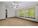 Spacious main bedroom featuring light-grey walls, two windows with green views, and a ceiling fan at 7320 Oak Arms Dr, Villa Rica, GA 30180