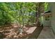 Lush side yard with mature trees and shade plus a concrete walkway along the side of the house at 7320 Oak Arms Dr, Villa Rica, GA 30180