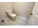 Neat powder room featuring a modern toilet, white marble floors, and a freshly painted door at 1021 Liberty Springs Dr, Woodstock, GA 30188
