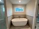 Bright bathroom featuring a freestanding tub, shiplap accent wall, and a window with a view at 1021 Liberty Springs Dr, Woodstock, GA 30188