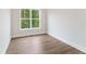 Bright, neutral bedroom with hardwood floors and a large window overlooking nature at 1021 Liberty Springs Dr, Woodstock, GA 30188