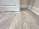 Modern wood-look tile flooring complemented by white baseboards at 1021 Liberty Springs Dr, Woodstock, GA 30188