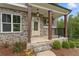 Charming front porch featuring stone columns and a view of the landscaped front yard at 1021 Liberty Springs Dr, Woodstock, GA 30188