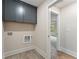 Laundry room with gray cabinets, modern flooring, and natural light at 1021 Liberty Springs Dr, Woodstock, GA 30188