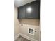 Functional laundry room with gray cabinets and wood-look tile flooring at 1021 Liberty Springs Dr, Woodstock, GA 30188