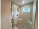 Bright shower featuring marble-look tile, a frameless glass door, mosaic flooring, and convenient corner shelving at 1021 Liberty Springs Dr, Woodstock, GA 30188