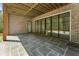Covered back porch with slate flooring, brick facade, and sliding glass doors overlooking the backyard at 117 Owens Mill Pl, Canton, GA 30115