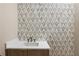 Modern bathroom featuring a decorative accent wall and vanity with marble countertop at 117 Owens Mill Pl, Canton, GA 30115
