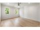 Spacious bedroom with light hardwood floors, white walls, and two large windows with backyard view at 117 Owens Mill Pl, Canton, GA 30115
