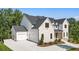 Two-story white brick home features a three-car garage and manicured landscaping at 117 Owens Mill Pl, Canton, GA 30115