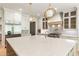 Gourmet kitchen featuring an oversized island, custom range hood and stainless steel appliances at 117 Owens Mill Pl, Canton, GA 30115
